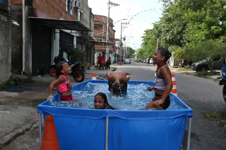 Tânia Rêgo/Agência Brasil Rio de Janeiro (RJ), 16/11/2023 - Moradores do Complexo da Maré se refrescam com chuveiros e piscinas improvisadas nas ruas da comunidade. A sensação térmica na cidade do Rio de Janeiro voltou a superar os 50 graus Celsius (°C), com a onda de calor que atinge boa parte do Brasil. Foto: Tânia Rêgo/Agência Brasil